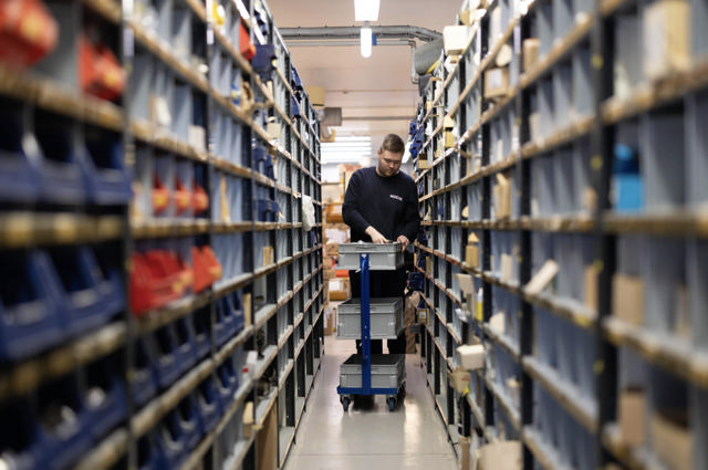 Person sorterer reservedeler på lager